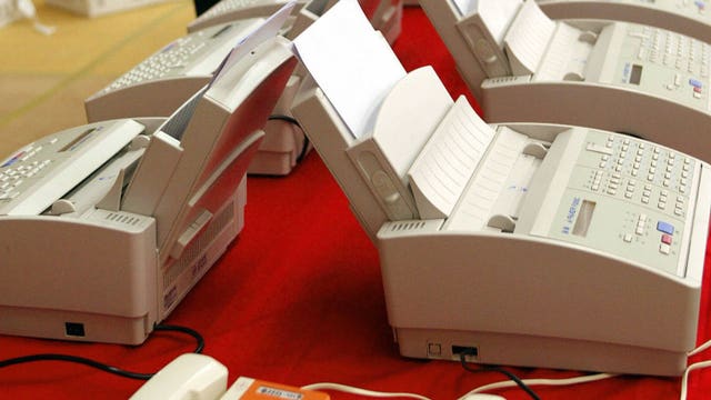 Faxes and email: Old technology slows COVID-19 response