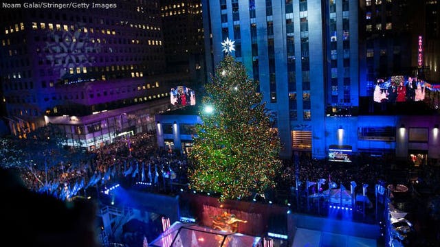 Crowd, bundled against chill, views Rockefeller Center tree