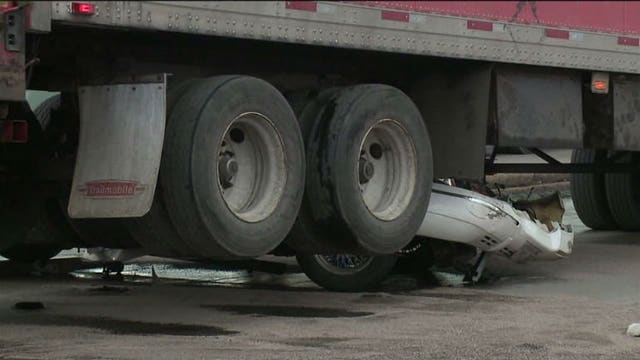 Driver chokes, accelerates into intersection, semi drives up onto car's front end!