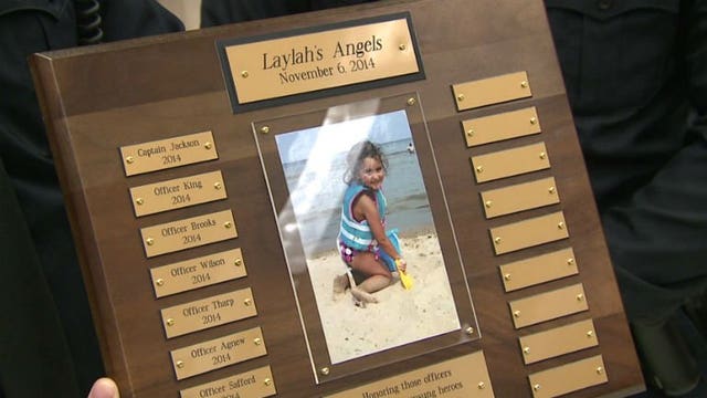 Family of five-year-old Laylah Petersen presents plaque to officers involved in investigation