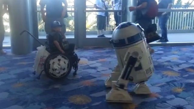 Boy in wheelchair playfully dances with fan-made R2-D2