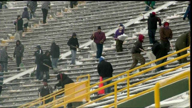 Shovelers help clear away snow from Lambeau Field