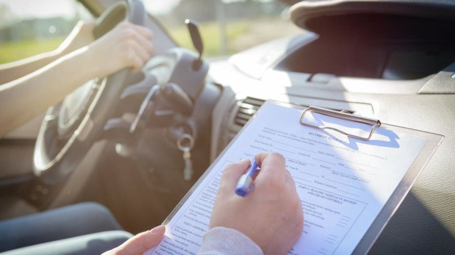 Examiner filling in driver's license road test form