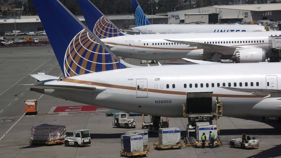 United Airlines workers load cargo onto a plane at San Francisco International Airport on July 08, 2020 in San Francisco, California. (Photo by Justin Sullivan/Getty Images)