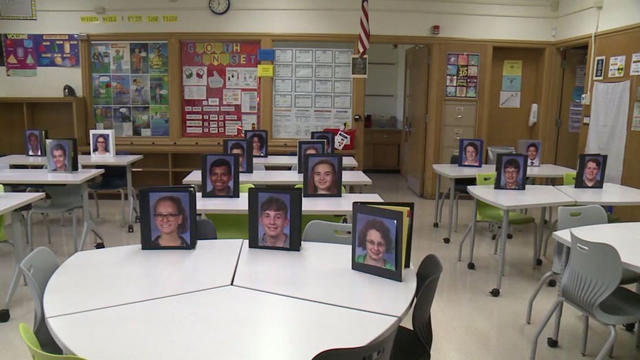 Elena Olive puts student photos on binders to fill her classroom at Walden High School in Racine