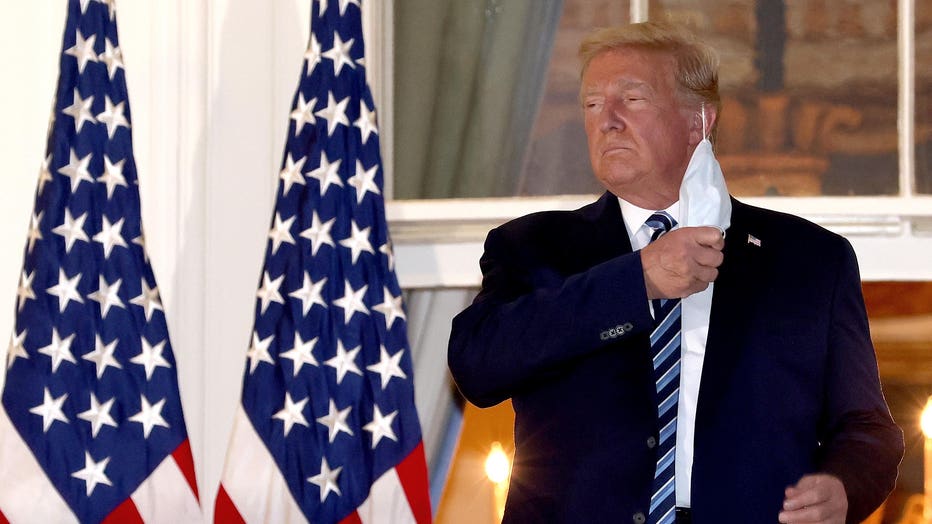 President Donald Trump removes his mask upon return to the White House from Walter Reed National Military Medical Center on Oct. 5, 2020 in Washington, D.C. (Photo by Win McNamee/Getty Images)