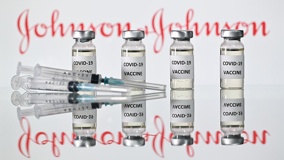 An illustration picture shows vials with Covid-19 Vaccine stickers attached and syringes with the logo of US pharmaceutical company Johnson & Johnson