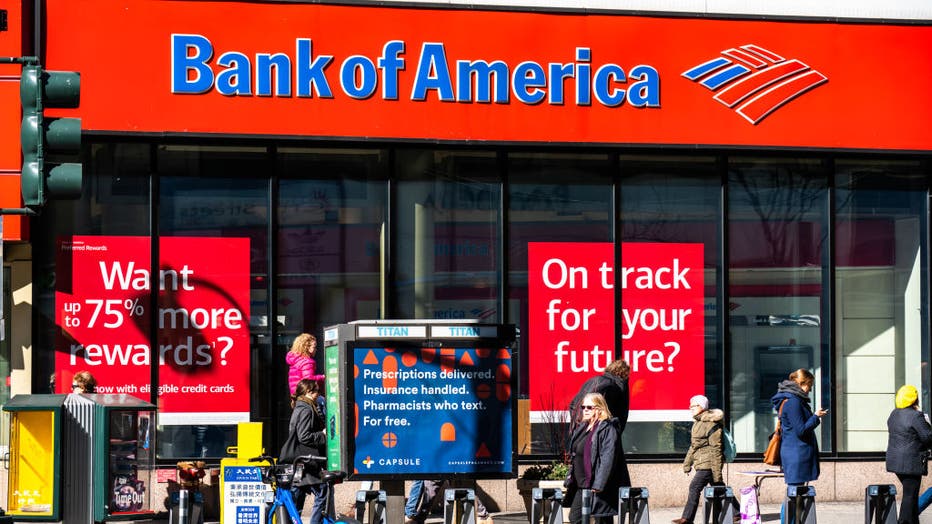 Pedestrians walk past a branch of Bank of America in New