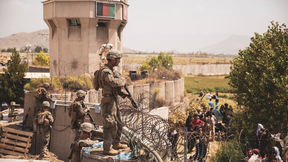 U.S. Marines assist with security at an Evacuation Control Checkpoint during an evacuation at Hamid Karzai International Airport in Kabul, Afghanistan.
