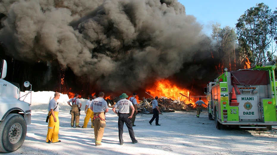 Firemen watching a controlled burn of trees on West Okeechobee Road.