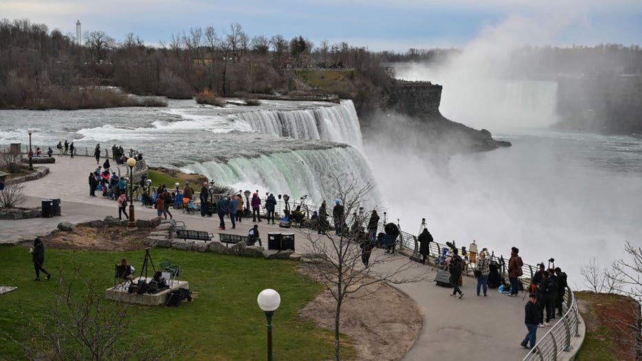 People gather at Niagara Falls State Park ahead of a total solar eclipse across North America, in Niagara Falls, New York, on April 8, 2024. (Photo by ANGELA WEISS/AFP via Getty Images)