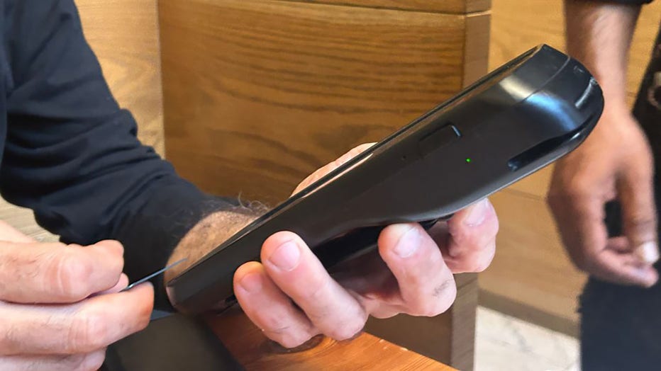 FILE - Customer self check out at restaurant using hand held credit card scanner, Manhattan, New York. (Photo by: Lindsey Nicholson/UCG/Universal Images Group via Getty Images)