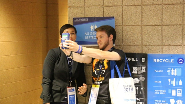 People stop for selfies outside Gender neutral bathroom at DNC