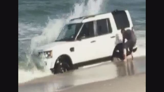 SUV sinks in New Jersey beach as owner tries to save it - VIDEO