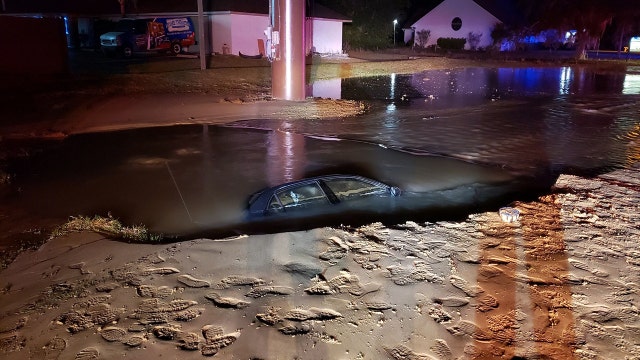 Driver sinks into watery hole after hitting fire hydrant