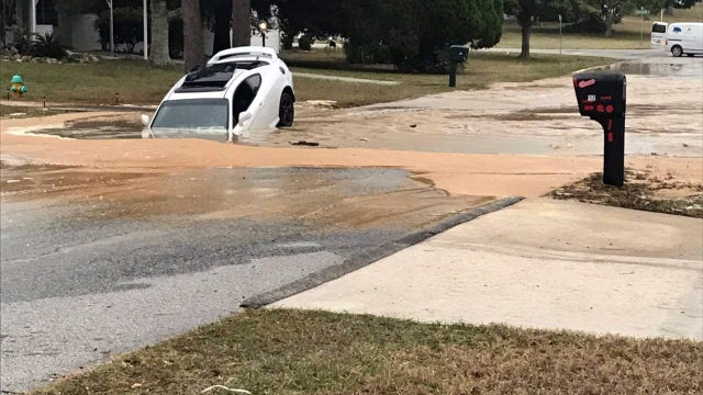 Vehicle engulfed in massive hole caused by water main break in Citrus