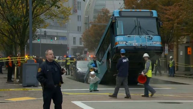 Sinkhole opens, swallows part of city bus during rush hour