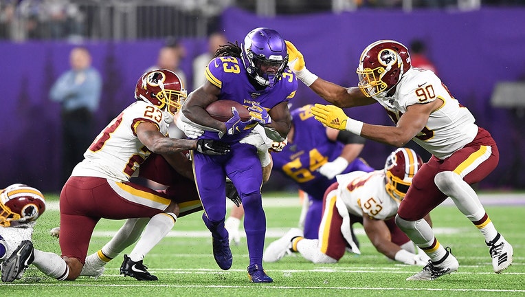 MINNEAPOLIS, MINNESOTA - OCTOBER 24: Running back Dalvin Cook #33 of the Minnesota Vikings runs against the defense of Montez Sweat #90 and Quinton Dunbar #23 of the Washington Redskins in the game at U.S. Bank Stadium on October 24, 2019 in Minneapolis, Minnesota. (Photo by Hannah Foslien/Getty Images)