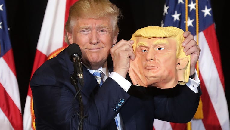 SARASOTA, FL - NOVEMBER 07: Republican presidential nominee Donald Trump holds up a rubber mask of himself during a campaign rally in the Robarts Arena at the Sarasota Fairgrounds November 7, 2016 in Sarasota, Florida. With less than 24 hours until Election Day in the United States, Trump and his opponent, Democratic presidential nominee Hillary Clinton, are campaigning in key battleground states that each must win to take the White House. (Photo by Chip Somodevilla/Getty Images)