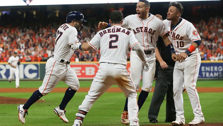 HOUSTON, TEXAS - OCTOBER 19: Jose Altuve #27 of the Houston Astros is mobbed by Alex Bregman #2, Carlos Correa #1 and Yuli Gurriel #10 as he approaches home plate after hitting a walk-off home run against the New York Yankees to winGame 6 of the American League Championship Series at Minute Maid Park on October 19, 2019 in Houston, Texas. (Photo by Bob Levey/Getty Images)