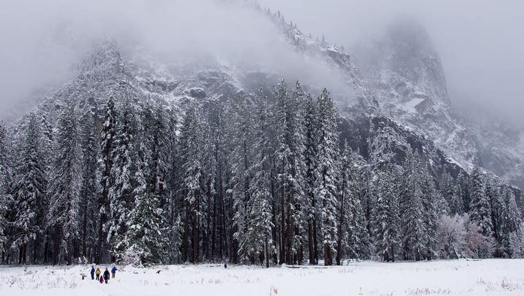 A family enjoys the first snow of the season in Cook's Meadow overlooking Sentinnel Rock. Nov. 26, 2019