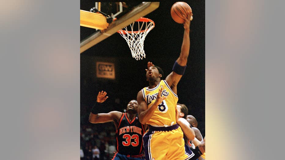 INGLEWOOD, UNITED STATES: New York Knicks Patrick Ewing (L) can't stop Los Angeles Lakers Kobe Bryant's drive to the basket in first quarter action 28 March 1999 at the Great Western Forum in Los Angeles. The Lakers won 99-91. AFP PHOTO/Gerard BURKHART (Photo credit should read GERARD BURKHART/AFP via Getty Images)