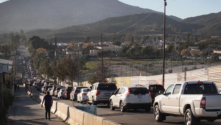 TACATE, MEXICO - JANUARY 27: Motorists heading to the United States from Mexico wait along U.S. border wall to pass through the port of entry on January 27, 2019 in Tecate, Mexico. The U.S. government had been partially shut down as President Donald Trump battled congress for $5.7 billion to build walls along the U.S. border with Mexico. Despite President Trump agreeing to end the shutdown, the debate over border wall funding continues. (Photo by Scott Olson/Getty Images)