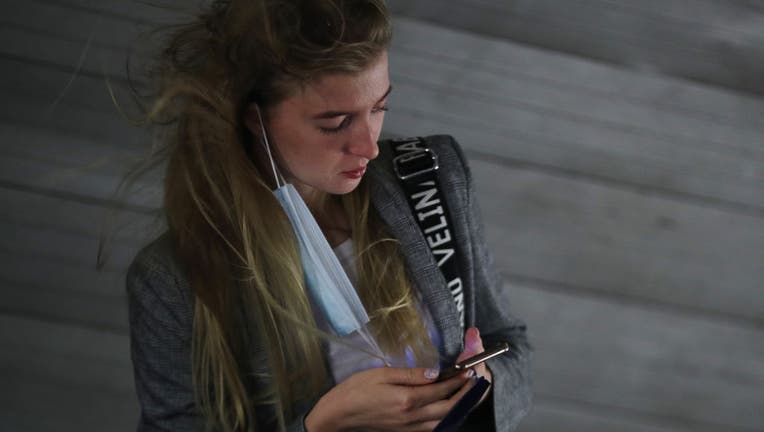 Woman With Mask Using Iphone