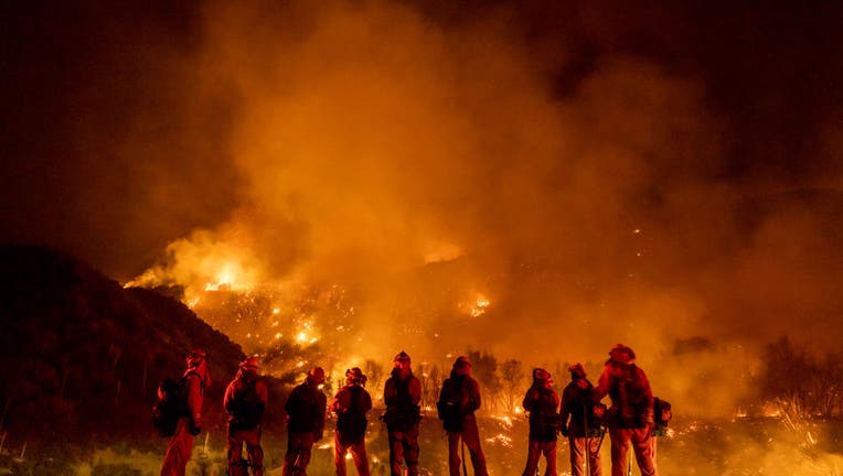 September 9: A group of inmate firefighter watch as the El Dorado Fire burns a hillside near homes in Mountain Home Village, California, inside the San Bernardino National Forest, September 9, 2020.