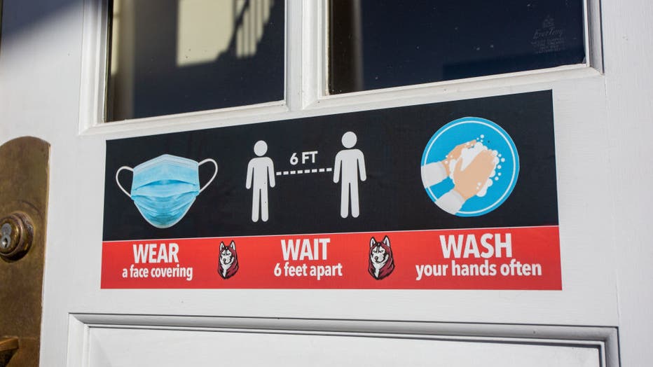 A sign that reminds people to wear a mask, wash their hands