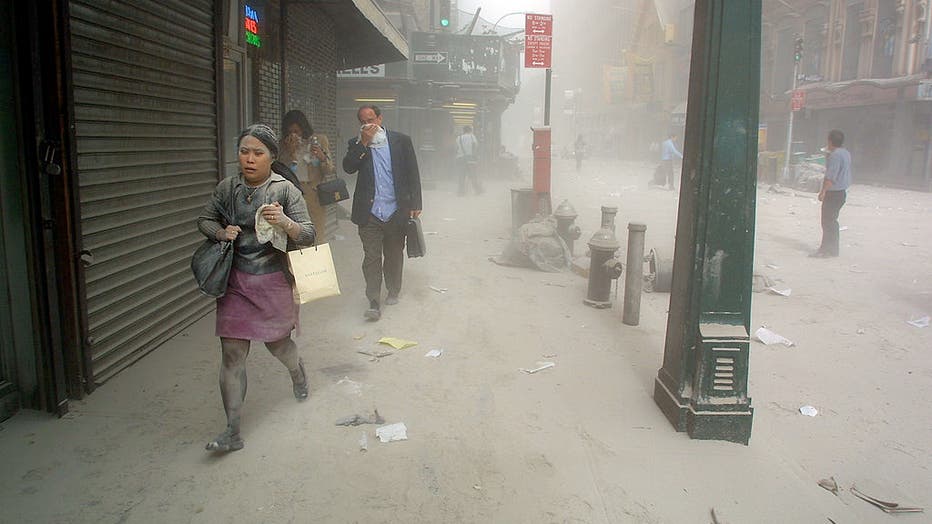 Pedestrians walk through soot after the