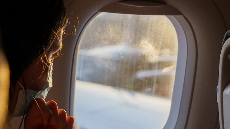 26 September 2021, Spain, Palma De Mallorca: A female passenger wearing a mask looks out of the window before take-off. Aeropuerto de Son San Juan Airport is one of three international commercial airports in the Balearic Islands. In 2019, almost 30 million passengers were handled. Photo: Andreas Arnold/dpa (Photo by Andreas Arnold/picture alliance via Getty Images)