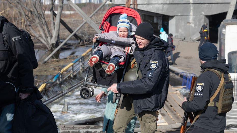 A serviceman carrying a kid during the evacuation.
Thousands