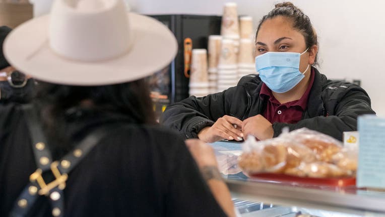 People shop with face coverings in Newhall, CA. LA County may issue a public health order on Friday to end the requirement to wear masks indoors.