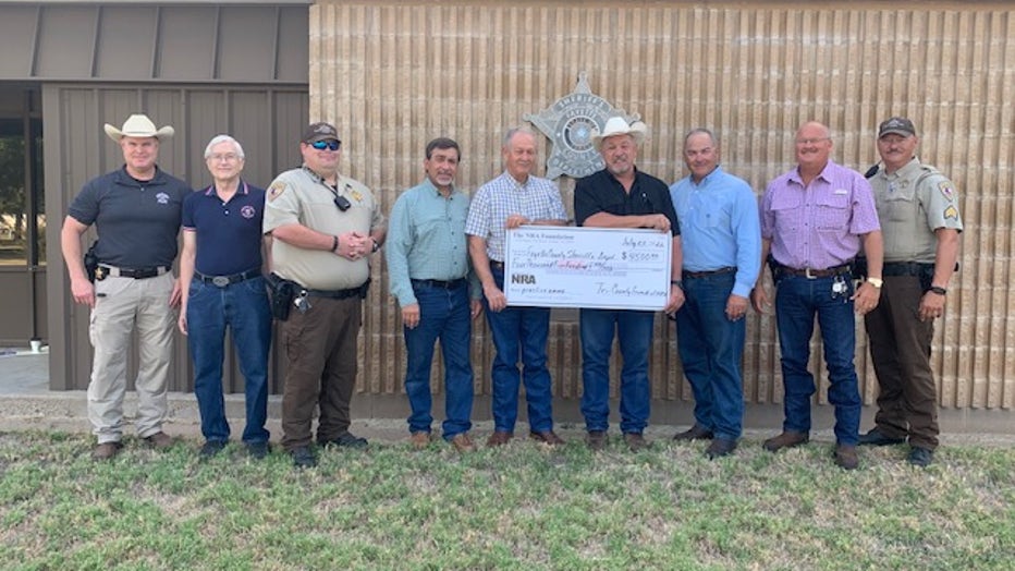 From left to right are: Investigator Kenn Kretz, Charles Murray, Deputy Lee Phillips, John Salem, Dennis Brower, Sheriff Keith Korenek, Craig Schulz, Lt. David Beyer and Sgt. Ron Naumann, all pictured with a giant check for $4,500 from the NRA Foundation and Friends of NRA.