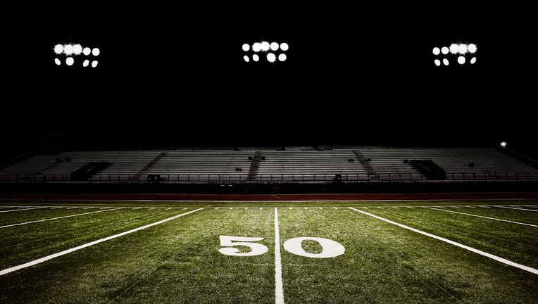 Fifty-yard line of football field at night