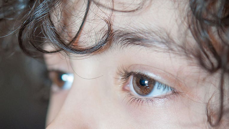 Child boy big brown eyes: A close-up of a young boy's dark