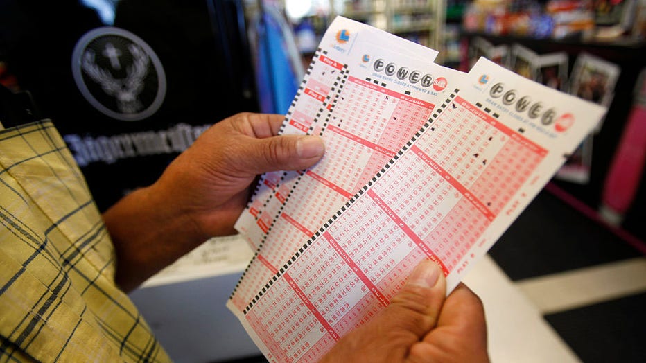 Rafael Moreno picks his lucky numbers as people form a line at Bluebird Liquor located on Hawthorne