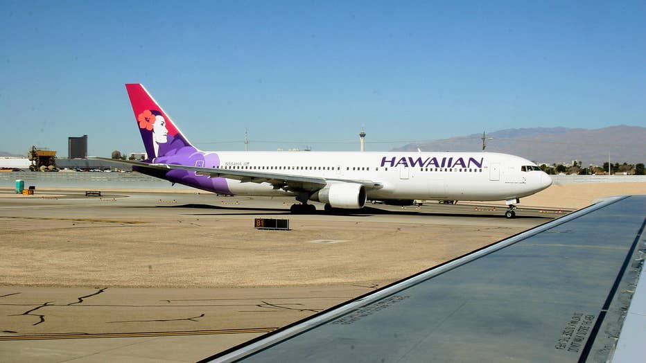 A Hawaiian Airlines jet taxies out to th
