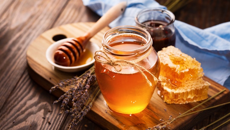 Honey in jar and bunch of dry lavender