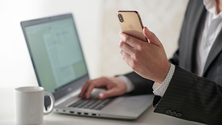 Man-uses-phone-and-computer.jpg