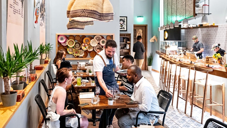 Waiter-serves-customers-at-restaurant.jpg