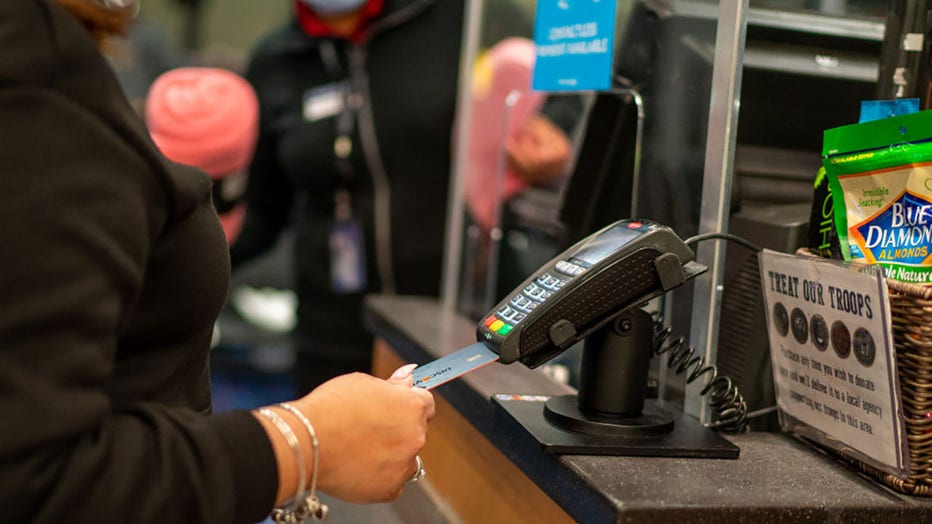 FILE - An air traveler uses a credit card to pay for items Jan. 28, 2022, at a retail shop in John F. Kennedy International Airport in New York City. (Photo by Robert Nickelsberg/Getty Images)