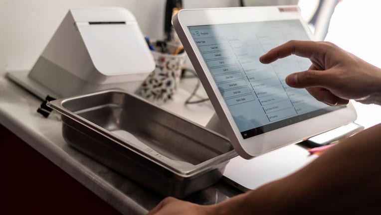 FILE - Employees run the cashier in front of a restaurant on Aug. 19, 2022, in Washington, D.C. (Photo by Anna Moneymaker/Getty Images)