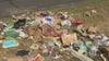 Austin garbage truck dumps trash on side of the road