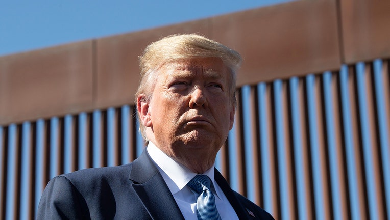 FILE -  US President Donald Trump visits the US-Mexico border fence in California.