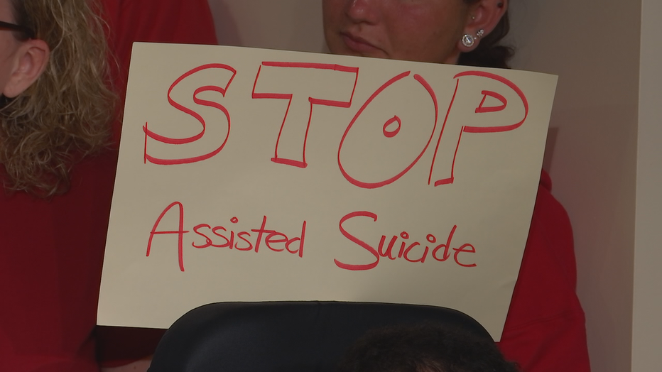 Opponents hold signs during protest against bill.