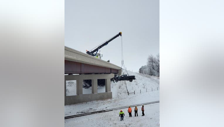 Crane removes pickup truck from railroad tracks