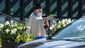 Priest uses squirt gun to shoot holy water and maintain social distancing