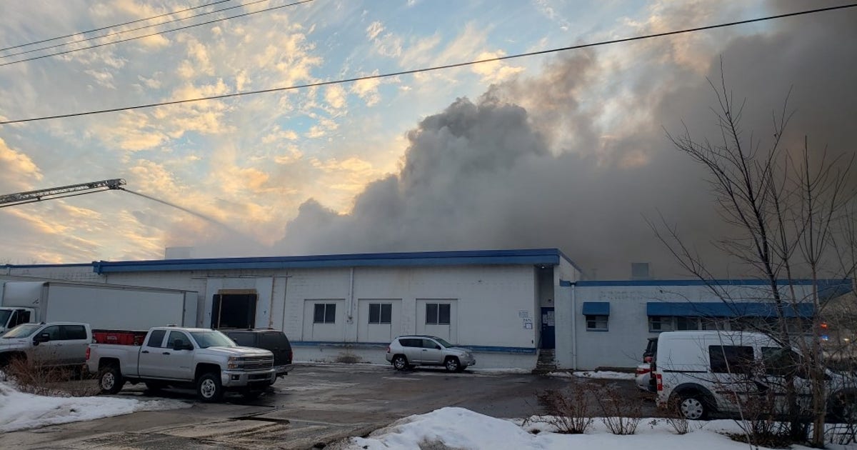 Section of warehouse partially collapses as crews battle large fire in ...